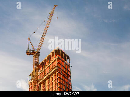 the top of a nyc building under construciton with a crane on the upper west side of manhattan Stock Photo