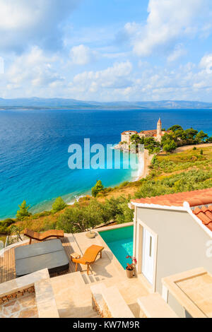 View of famous Dominican monastery on beach in Bol town with holiday apartment terrace in foreground, Brac island, Croatia Stock Photo