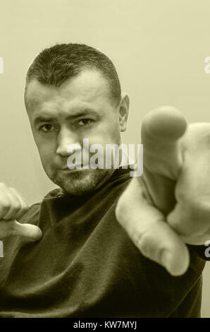 sad man is pointing his finger at the camera on green and white Stock Photo