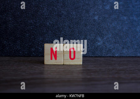 NO , on wood cube against dark background Stock Photo