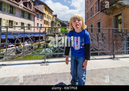 Child pulling his tongue out in annoyance while on vacation in Annecy, France Stock Photo