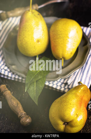 Fresh ripe pears on metal vintage late on rustic wooden table Stock Photo