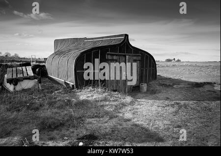 Old Upturned Herring Boats used as fishermans stores on the island of Lindisfarne on the Northumbrian Coast, UK,GB, EnglandUK Stock Photo