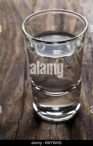 German hard liquor Korn Schnapps in shot glass on rustic wooden table Stock Photo