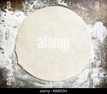 Roll out dough for pizza. On a rustic background. Stock Photo