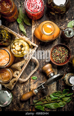 Various preserved vegetables and mushrooms with seamer and spices. On a wooden background. Stock Photo