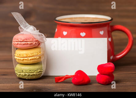 colorful macarons cake tied  ribbon, cup of coffee, empty blank and red hearts, St. Valentines day concept Stock Photo