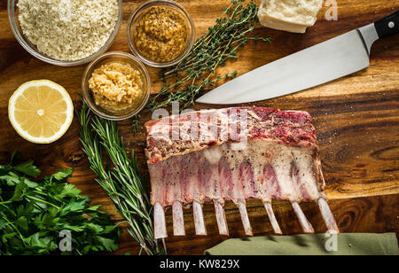 Cooking a roasted rack of lamb for dinner with a herbed parmesan cheese crust.  Ingredients include rosemary, thyme, garlic, and mustard mixed with br Stock Photo