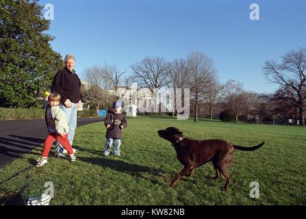 President William Jefferson Clinton and nephews Tyler Clinton and Zach Rodham playing with Buddy the Dog on the White House lawn, December 25, 1999. Stock Photo