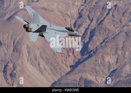 US Navy F/A-18E Super Hornet Jet Fighter Flying At Low Level Into The Panamint Valley In Death Valley National Park California. Stock Photo