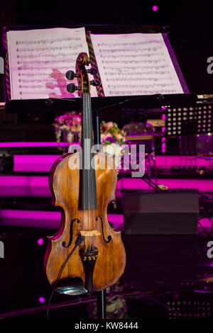 close up photo of vintage violin with bow and musical notes in concert hall Stock Photo