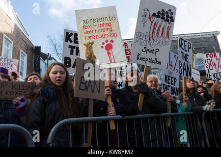 Protesters holding placards demonstrate against fox hunting as the Carmarthenshire Hunt parade through Carmarthen on New Year's Day 2018 Stock Photo