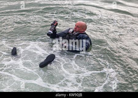 Poole, Dorset, UK. 1st Jan, 2018. Participant in water holding a bottle of Warre's Warrior port Finest Reserve at the New Years Day Bath Tub Race at Poole Quay Harbour. Credit: Carolyn Jenkins/Alamy Live News Stock Photo