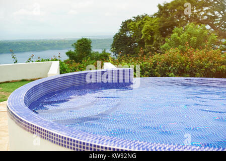 Side of round pool outdoor in green park background Stock Photo