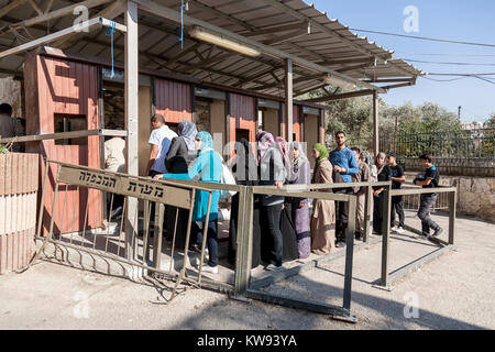 Hebron, Palestine, November 7 2010. Palestinian men and women queue at Israeli military check point by the Abraham mosque in old town of Hebron. Stock Photo