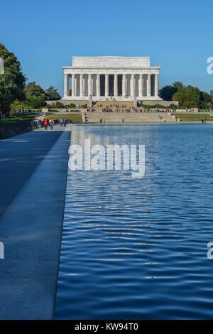 Portrait orientation of the Lincoln Memorial building with reflection in reflecting pool and some tourists, Washington DC, USA Stock Photo