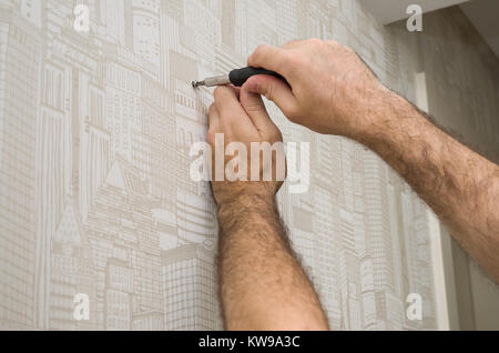 Great concept of residential renovation, man measuring wall with tape measure. Stock Photo