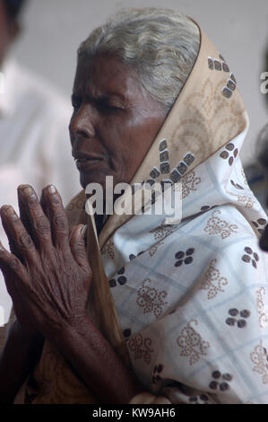 TAMIL NADU, INDIA, circa 2009: An unidentified woman prays in a Christian meeting, circa 2009 in Tamil Nadu, India. Catholics and Protestants make up  Stock Photo