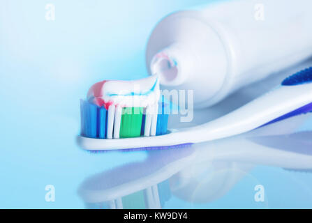 toothbrush with paste on a blue background with reflection Stock Photo