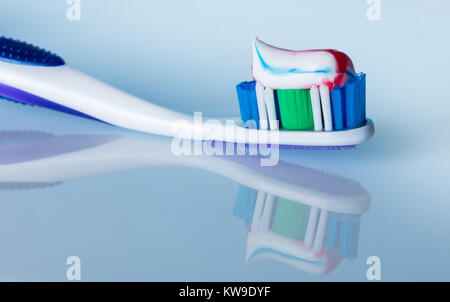 toothbrush with paste on a blue background with reflection Stock Photo