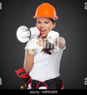 portrait of Female Construction Worker With Toolbelt south on megaphone Stock Photo