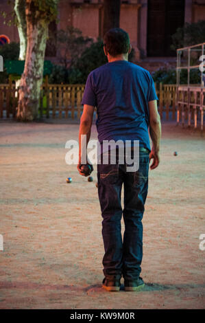 Corsica: a man playing petanque, the traditional Provencal game with boules originated in 1907 in France, in a square of Ile-Rousse (Red Island) Stock Photo