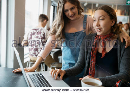 High school girl student friends studying,using laptop in cafe