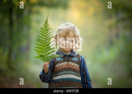 Young blonde boy with long curly hair Stock Photo