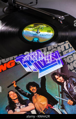 Vinyl record - Thin Lizzy 1975 vintage LP on turntable / record player. Stylus playing a track, label in view, album cover / sleeve alongside. Stock Photo