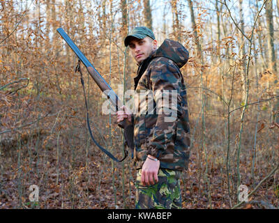 Hunter in camo suit with double barrel shotgun Stock Photo