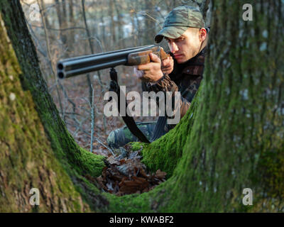 Hunter in camo suit with double barrel shotgun Stock Photo