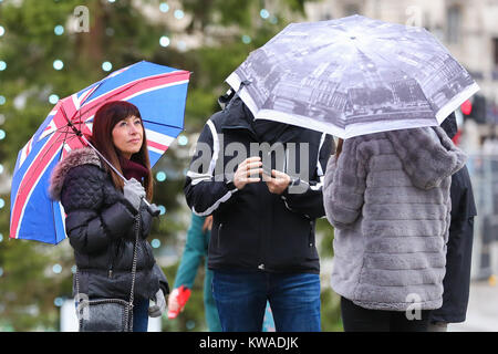 Trafalgar Square. London, UK. 1st Jan, 2018. Tourists shelter from the rain beneath umbrellas on the first day of 2018. Credit: Dinendra Haria/Alamy Live News Stock Photo