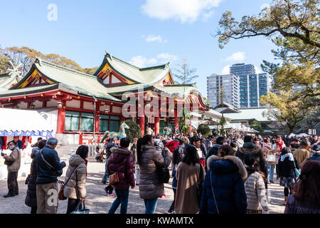 Japan, Nishinomiya Shinto shrine. People during their hatsumode, first visit of the new year, wandering around the shrine grounds in front of the main hall, Haiden. Many people, busy scene. Stock Photo