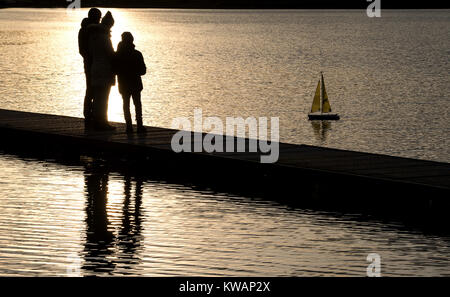 Stuttgart, Germany. 02nd Jan, 2018. A family watches a remote-controlled sailing boat from a footbridge at the Max Eyth lake in Stuttgart, Germany, 02 January 2018. Credit: Sebastian Gollnow/dpa/Alamy Live News Stock Photo
