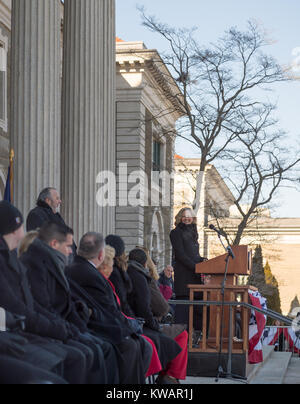 Mineola, New York, USA. January 1, 2018. Historic swearing-In of LAURA CURRAN as Nassau County Executive, the first female County Executive, is held outdoors. Temperature was a freezing 14 ℉ Fahrenheit / -10 ℃  Celsius for the outdoor ceremony held in front of Theodore Roosevelt Executive & Legislative Building, and people in audience stood close together on and near the vast entrance stairs steps. Welcome was by Mayor FRANCIS MURRAY of Rockville Centre. Stock Photo