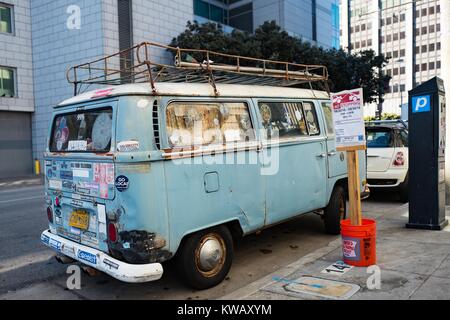 Beat up blue Volkswagen bus, covered in bumper stickers, parked along the street in the Tenderloin neighborhood of San Francisco, California, October 2, 2016. Stock Photo