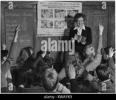 A sixth grade teacher shows her pupils on how to use War Ration Book Two, February, 1943. Stock Photo