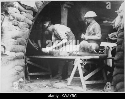 Scottish territorials being examined by two medical staff on a table in a dressing station inside a British bunker on the Western Front, during the Battle of Menin Road, with walls of sand bags and wooden planks, Belgium, 1917. Image courtesy National Archives. Stock Photo