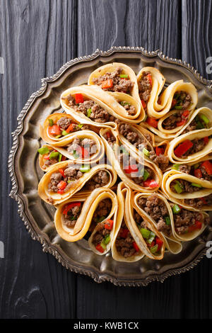 Pancakes stuffed with meat beef, peppers and onions closeup on a table. Vertical top view from above Stock Photo