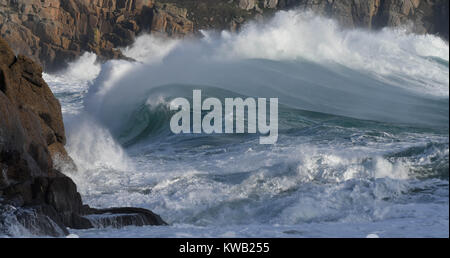 Stormy waves of winter down at the beach in Porthcurno, Cornwall just as Storm Elenor was picking up speed and force.  Shows the force of nature. Stock Photo