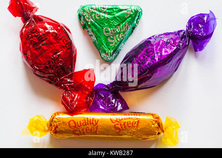 Quality Street a selection of 4 favourites chocolates by Nestle - the purple one, the green triangle, toffee finger & strawberry delight set on white Stock Photo