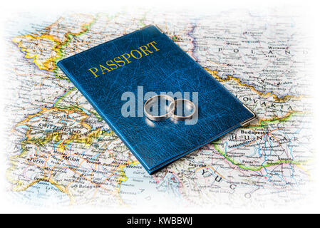 Honeymoon concept. Wedding rings with passports on the map. Stock Photo