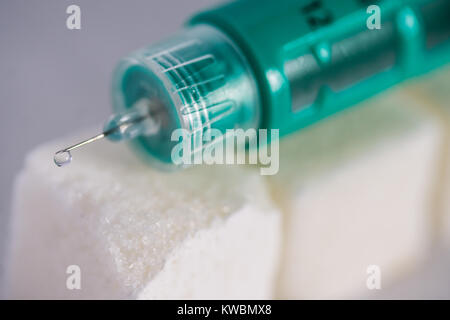 Concept image of Diabetes issues with Diabetic Insulin pen on top of Sugar lumps Stock Photo