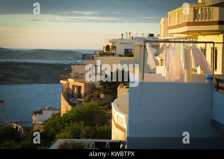 Washing drying on a balcony in Mellieha, Malta, evening light, with the sea behind Stock Photo