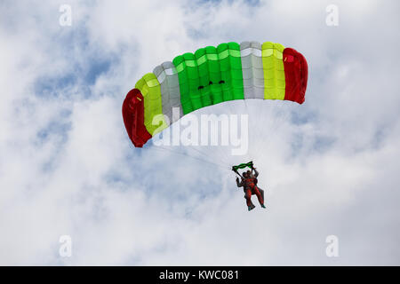 Descending tandem paratroopers on color parachute Stock Photo