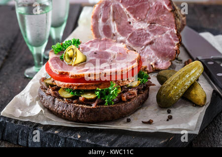 Opened homemade sandwich with smoked meat, tomato, onion jam and ico cold vodka Stock Photo