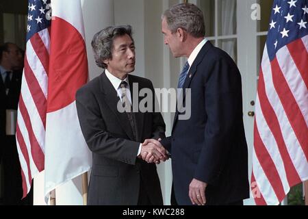 President George W. Bush shakes hands with Prime Minister Junichiro Koizumi of Japan. Sept. 25, 2001. Operation Enduring Freedom would start combat in Afghanistan on October 7, 2001. Japan would be a participant providing humanitarian aid. (BSLOC 2015 2 169) Stock Photo