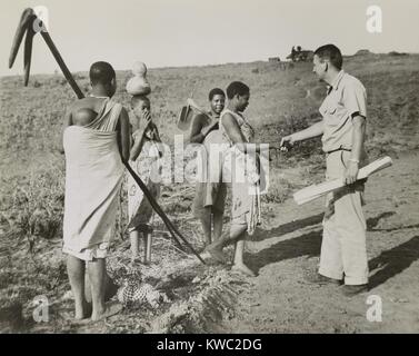 Peace Corps volunteer meeting four village women working in fields, Tanganyika, Oct. 17, 1962. The 1962 Peace Corp project in Tanganyika included surveying and training for road improvement. (BSLOC 2015 2 229) Stock Photo