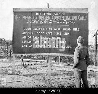 British soldier stands by a sign posted at the site of the Belsen Concentration Camp, 1945. Sign reads: 10,000 unburied dead were found here, another 13,000 have since died, all of them victims of the German new order in Europe, and an example of Nazi Kultur. World War 2 (BSLOC 2015 13 11) Stock Photo