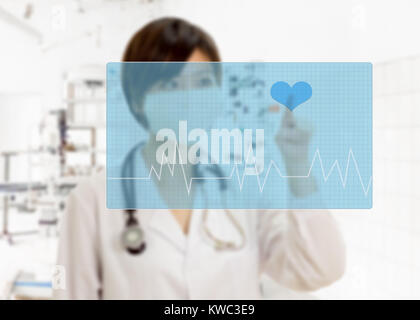 Defocused Asian American female doctor with stethoscope pressing heart button on virtual pulse screen in surgery Stock Photo